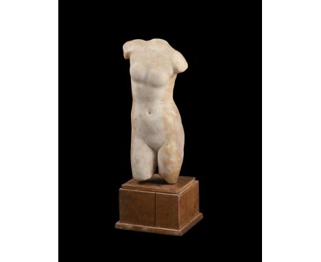 A SMALL ROMAN MARBLE TORSO OF APHRODITE  CIRCA 2ND CENTURY A.D.  Set on a walnut base  the torso 30.5cm high, 40.5cm high ove