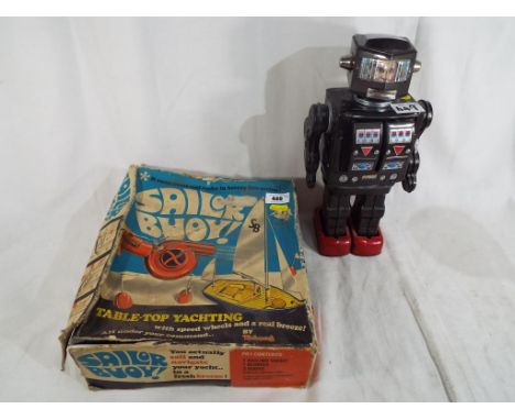 A table top yachting sailor buoy by Tri-ang, boxed and a tinplate robot with two springback doors opening to reveal lights on