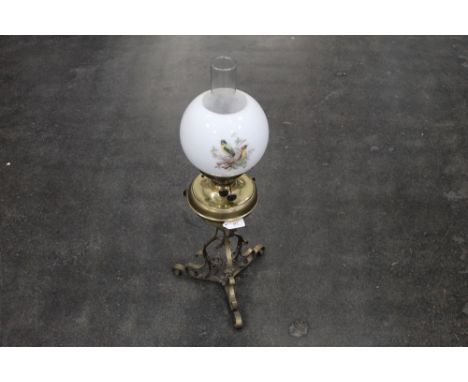 Vintage oil lamp with glass chimney and white decorative shade on metal stand 