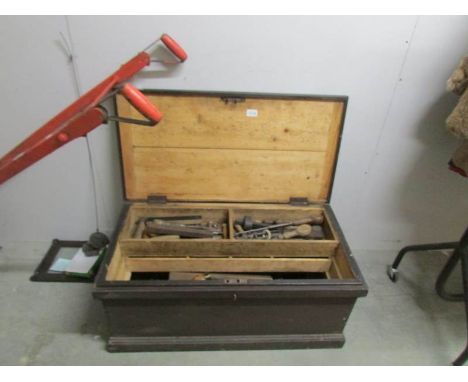 A pine tool chest containing old tools.
