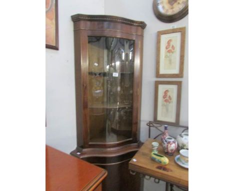 A mahogany bow front corner cabinet