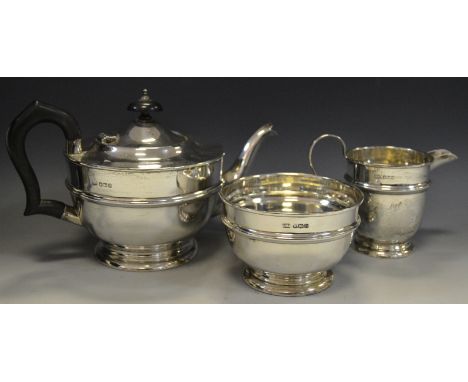 A silver three piece tea service, comprising of teapot, cream jug and sugar bowl by E.V, Sheffield.