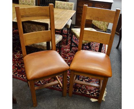 A pair of modern light oak dining chairs.