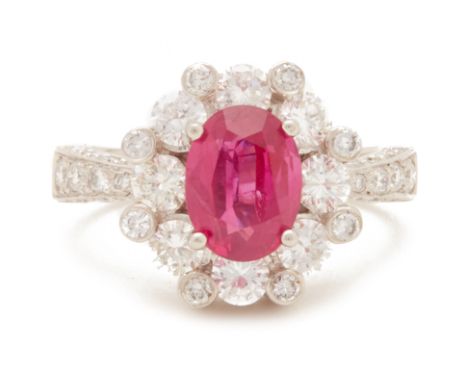 A BURMESE RUBY AND DIAMOND CLUSTER RING
Set in platinum and 18k gold, the central oval cut ruby, within a surround of round b