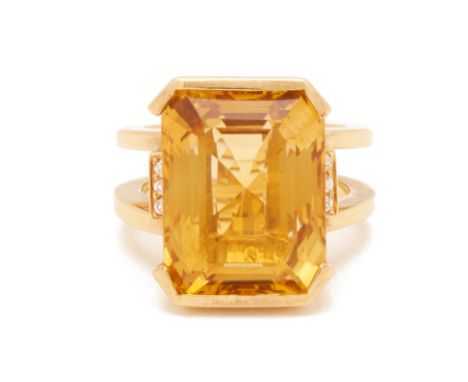 A YELLOW CITRINE COCKTAIL RING
Set in 18k gold, the large emerald cut citrine flanked by round brilliant cut diamonds to the 