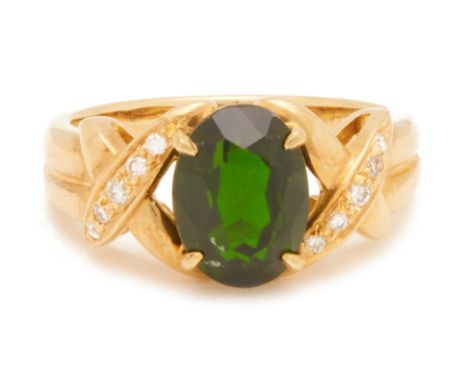 A CHROME DIOPSIDE AND DIAMOND RING
In 18k gold, the oval mixed cut central stone flanked by rows of round brilliant cut diamo