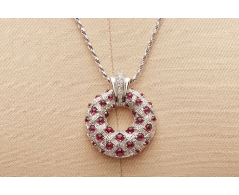 A RUBY AND DIAMOND PENDANT ON CHAIN
The circular pendant pave set with diamonds in a basket weave pattern interspersed with r