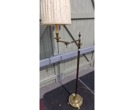 Edwardian brass adjustable swivel standard lamp upon fluted pedestal, circular base with paw feet.