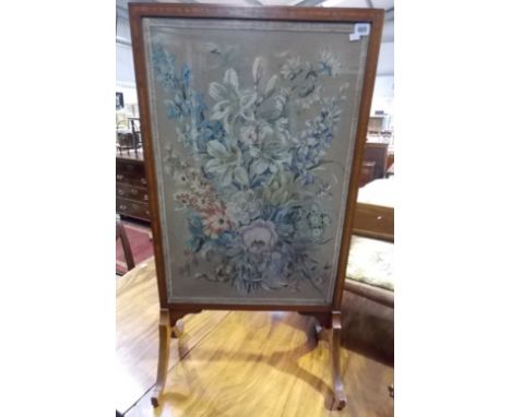 Edwardian mahogany strung rectangular firescreen with floral woolwork inset under glass, upon four outswept legs, height 40'.