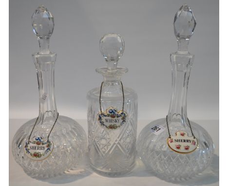 Pair of cut glass decanters and stoppers with ceramic wine labels, together with a cylindrical cut glass decanter and stopper