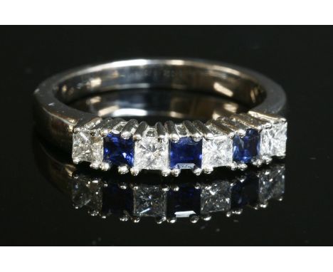A seven stone sapphire and diamond half hoop ring,with three calibré cut sapphires, claw set between four princess cut diamon