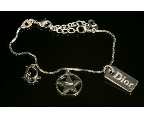 A Christian Dior silver-plated charm bracelet.three Dior charms, including a dog tag, circular star and Dior charm, suspended