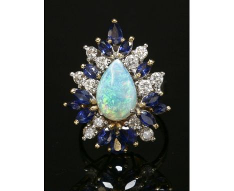 A Continental opal, diamond and sapphire pear-shaped cocktail cluster ring,with an oval cabochon opal, four claw set to the c