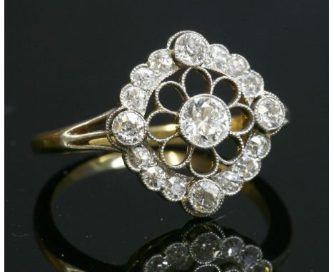 A Belle Époque diamond set cluster ring,with an old brilliant cut diamond, milligrain set to the centre in a white collet.  A