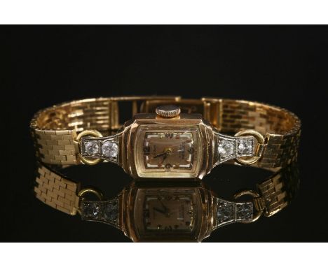 A ladies' gold Crown mechanical bracelet watch,with a tonneau case with Arabic numerals and dot batons to a champagne dial, w