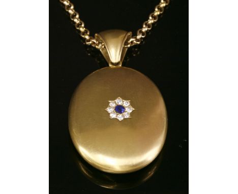 A Victorian, oval, gold, hinged locket, with a sapphire and diamond cluster to the front cover,a circular Swiss cut sapphire 