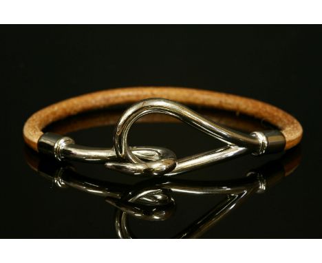 An Hermès 'Jumbo' brown leather bracelet,a smooth brown leather cord with a silver tapered loop and hook fastening.  Signed '