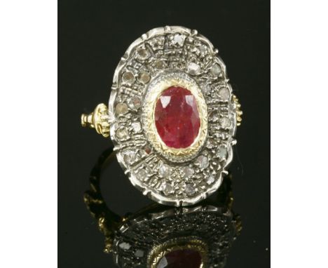 An Italian ruby and diamond oval plaque ring, with an oval mixed cut ruby, rub set to a yellow collet with incised chevron de
