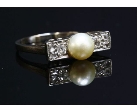 An Art Deco white gold, pearl and diamond ring, with a bouton-shaped pearl, 5.9mm, cup and peg set at the centre.  A flat sec