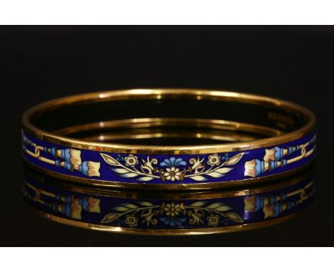 An Hermès narrow enamel bangle with gold-plated hardware,royal blue enamel ground with a printed garlands and tassel design. 