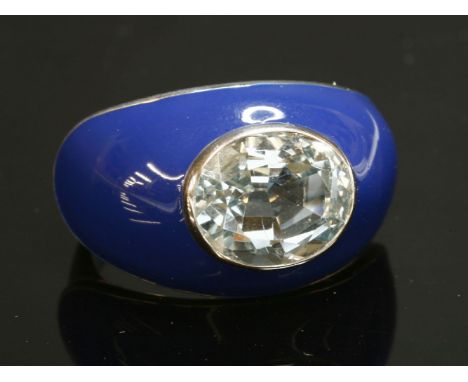 An Italian white gold, aquamarine and enamel bombé ring,with an oval mixed cut aquamarine, rub set to a blue enamel head with