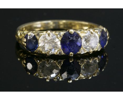 A late Victorian sapphire and diamond carved head ring, with three oval mixed cut sapphires and two old European cut diamonds