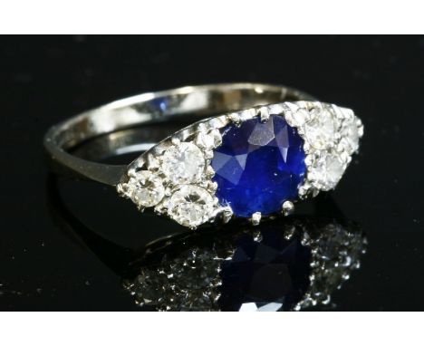 A seven stone sapphire and diamond boat-shaped ring,with a central cushion-shaped mixed cut sapphire.  A trefoil cluster of b