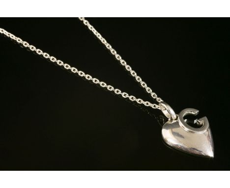 A Gucci silver heart pendant necklace.an heart and cut-away 'G' design pendant, suspended on a trace chain, with lobster claw