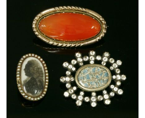 A Georgian black dot paste brooch, c.1790,with woven gold thread beneath an oval glazed cover, with a gold frame at the centr