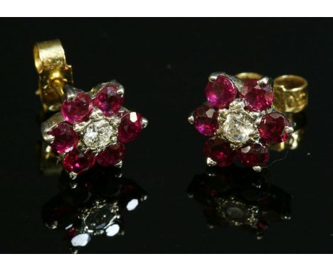 A pair of 18ct gold, diamond and ruby cluster earrings,with a brilliant cut diamond, illusion set to the centre.  A border of