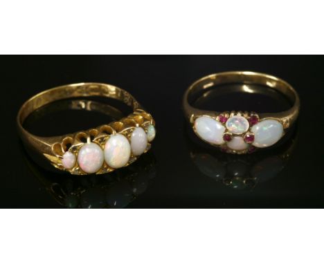 A late Victorian opal and ruby boat-shaped ring,with two parallel oval cabochon opals, with a pear-shaped cabochon opal at ea