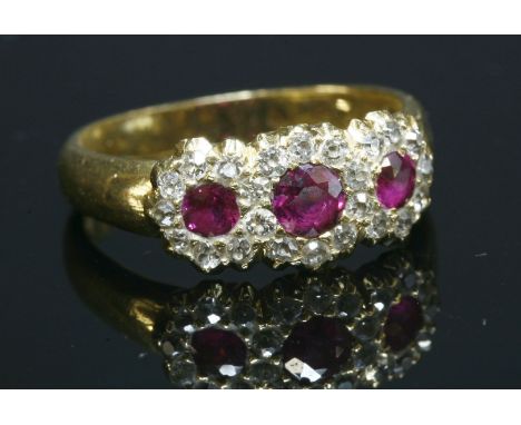 An Edwardian ruby and diamond triple cluster ring, with three graduated circular old mixed cut rubies, all grain set and surr