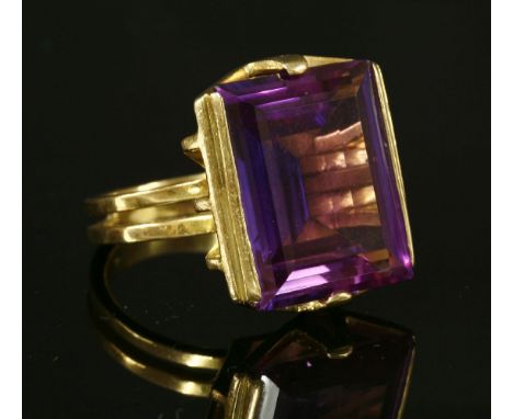 A Continental gold single stone synthetic sapphire ring, c.1970,with a rectangular step cut purple synthetic sapphire, end se