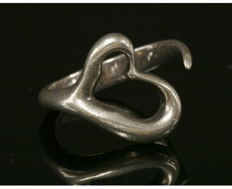 A silver open curved heart ring by Tiffany,designed by Elsa Peretti, with a polished graduated heart and graduated wraparound