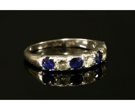 A sapphire and diamond half eternity ring,with four circular mixed cut sapphires and three brilliant cut diamonds all grain s