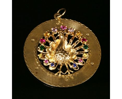 An American, synthetic spinel, gold peacock pendant, with a relief peacock to the centre, the tail claw set with graduated co