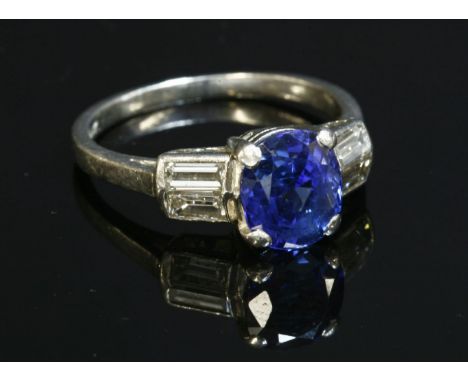 A sapphire and diamond ring,with an oval mixed cut sapphire, estimated as approximately 2.20ct, four claw set to a plain coll