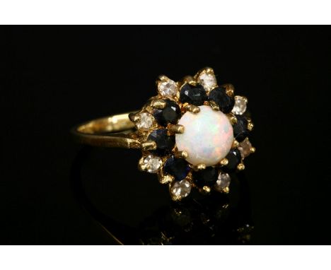 An 18ct gold opal, sapphire and diamond cluster ring,with a circular cabochon opal, claw set to the centre, with outer rows o