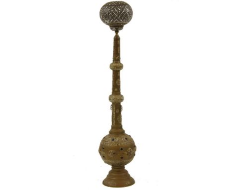 An Eastern brass standard lamp, with pierced shade, tapering foliate cast support and circular spreading base, 150cm high