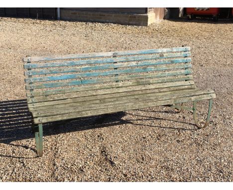 An Edwardian garden bench, with painted scroll iron supports, 180cm wide