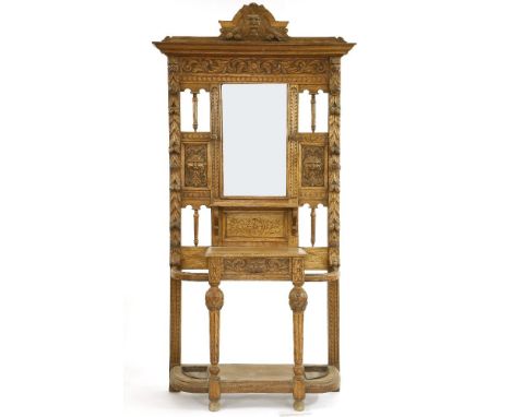 A large Victorian oak hall stand, with profusely carved oak surround around mirror plate over glove box and stick stand105 x 