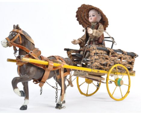 A charming antique 19th century likely French or German made automaton style bisque headed doll on a horse and trap / cart to