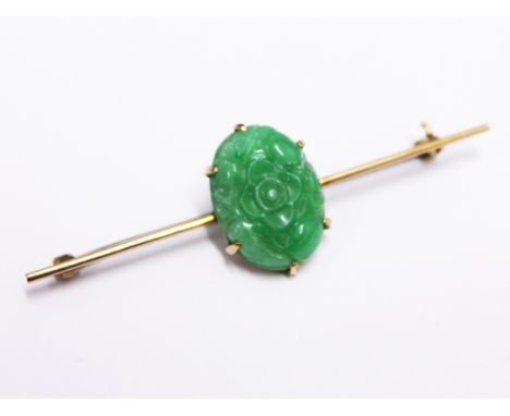 A gold jade cabochon brooch marked 10K, length 5.6cm, gross wt. 4.4g