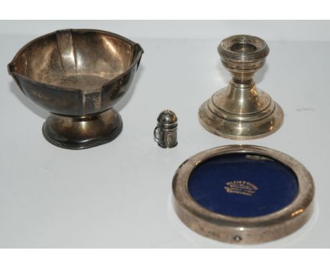 A silver dish, Birmingham, 1909, silver photo frame, 10cm wide, silver pepperette and silver chamber candle stick, various ma