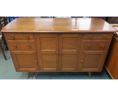 A mid 20th century elm and beech Ercol sideboard with two central cabinet doors flanked by two drawers above cabinet door eit