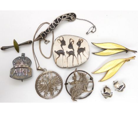 Two silver David Andersen yellow enamel leaf brooches, a ceramic Danish brooch depicting deer, a silver Ortak Maeshowe dragon