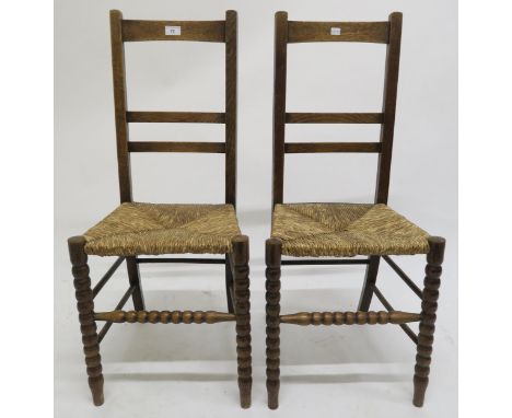A pair of early 20th century oak arts &amp; crafts chairs with rush seats on turned bobbin supports, 90cm high Condition Repo