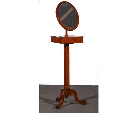 A Victorian mahogany shaving mirror on stand, adjustable oval mirror, over two hinged compartments, fluted column, moulded tr
