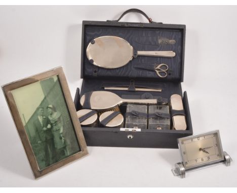 A travel vanity case, containing silver mounted jars, brushes, hand mirror, comb etc, hallmarked London 1943,  a chrome plate