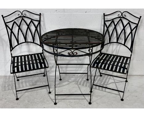 A vintage metal Bistro set containing one table and two chairs.